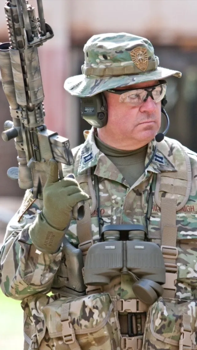 A man in camouflage holding an ar-1 5 rifle.